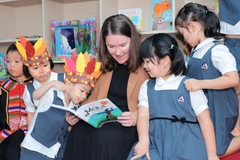 Phó Đại sứ New Zealand tại Việt Nam đọc sách cho các em thiếu nhi.(Ảnh: PV/Vietnam+)