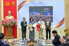 Tổng Biên tập Báo Nhân Dân Lê Quốc Minh và Phó Chủ tịch thường trực Hội Nhà báo Việt Nam Nguyễn Đức Lợi trao giải A cho các tác giả. (Ảnh: CTV/Vietnam+)