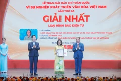 Phó Thủ tướng Mai Văn Chính và Bộ trưởng Bộ Văn hoá, Thể thao và Du lịch Nguyễn Văn Hùng trao giải Nhất cho tác giả Đỗ Minh Thu, Báo Điện tử Vietnam Plus, Thông tấn xã Việt Nam. (Ảnh: Minh Quyết/TTXVN)