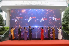 Các đại biểu thực hiện nghi thức khai mạc triển lãm. (Ảnh: CTV/Vietnam+)