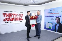 Nhà báo Nguyễn Thiện Thuật, Tổng Biên tập Báo Thể thao và Văn hóa trao hoa và Bằng chứng nhận Đại sứ truyền cảm hứng cho nhạc sỹ Nguyễn Văn Chung (trái). (Ảnh: PV/Vietnam+)