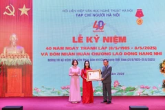 Tổng Biên tập Vương Minh Huệ đón nhận Huân chương Lao động hạng Nhì dành cho Tạp chí Người Hà Nội. (Ảnh: Đại Thắng/Vietnam+)