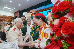 Thiếu tướng Phan Văn Lai tặng sách cho các đồng đội, cựu chiến binh. (Ảnh: PV/Vietnam+)