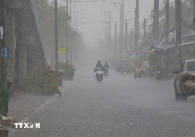 Người dân cần chú ý khi đi ra ngoài trong lúc mưa dông. (Ảnh: Duy Khương/TTXVN) ttxvn-mua-dong-2208.jpg