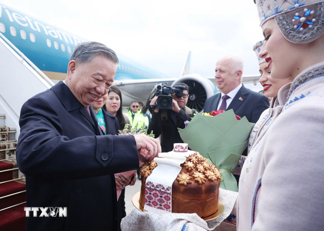 Thiếu nữ Belarus trong trang phục truyền thống trân trọng mời Tổng Bí thư Tô Lâm thưởng thức bánh mì và muối theo nghi thức đón khách quý của Belarus. (Ảnh: Thống Nhất/TTXVN) ttxvn-tong-bi-thu-to-lam-den-minsk-bat-dau-tham-cap-nha-nuoc-toi-belarus-1105-9.jpg
