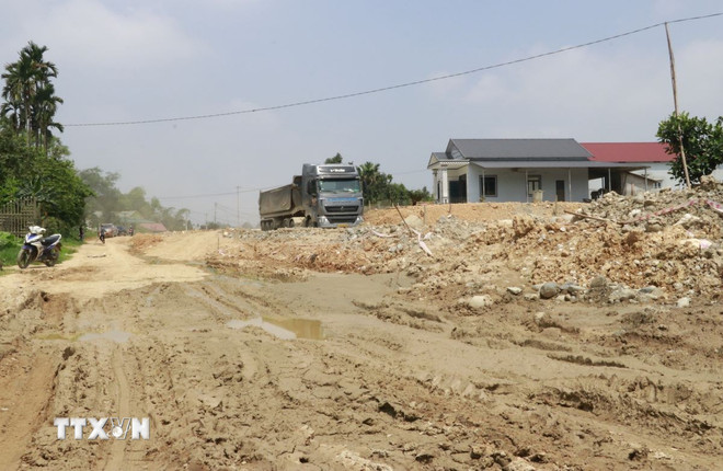 Người dân thôn Hạnh Phúc, xã Y Can, huyện Trấn Yên (Yên Bái) lo lắng nhà bị thấp sâu hơn đường sẽ gây ngập úng. (Ảnh: Đinh Thùy/TTXVN) ttxvn-yen-bai-day-nhanh-tien-do-thi-cong-tinh-lo-166-noi-cao-toc-noi-bai-lao-cai-1205-2.jpg