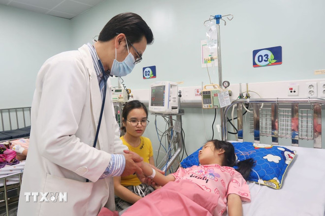 Tiến sỹ, bác sỹ Nguyễn Minh Tuấn, Trưởng Khoa Sốt xuất huyết, Bệnh viện Nhi đồng 1 Thành phố Hồ Chí Minh, thăm khám cho bệnh nhi mắc sốt xuất huyết. (Ảnh: Đinh Hằng/TTXVN) ttxvn-sot-xuat-huyet-bung-phat-manh-gia-tang-truong-hop-mac-nang-2907-3.jpg