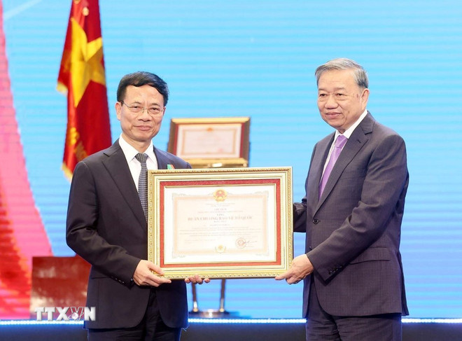 General Secretary To Lam presents the First Class Fatherland Protection Medal to Nguyen Manh Hung, member of the Party Central Committee and Minister of Science and Technology. (Photo: Thong Nhat/VNA) ttxvn-tong-bi-thu-du-le-ky-niem-80-nam-nganh-buu-chinh-va-vien-thong-2909-2.jpg
