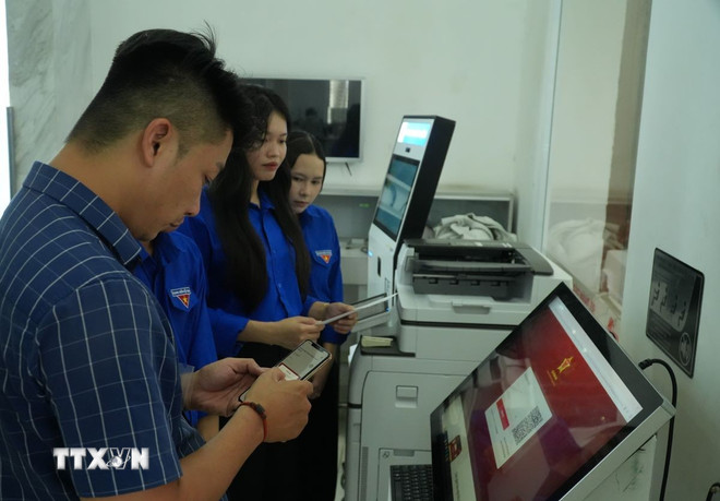 Hỗ trợ người dân khi làm thủ tục trực tuyến. (Ảnh: Hữu Duyên/TTXVN) ttxvn-chinh-quyen-dia-phuong-2-cap-o-sieu-do-thi-tp-ho-chi-minh-1410-3.jpg