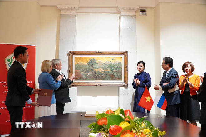 La Sra. Ngo Phuong Ly presentó la pintura “Palm Hills” del fallecido artista Phan Ke An. (Foto: Tam Hang/VNA) ttxvn-khai-mac-trien-lam-tranh-son-mai-viet-nam-tai-nga-31-3.jpg