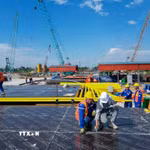 Công trường thi công dự án cầu Tứ Liên trên sông Hồng đang được triển khai với nhiều hạng mục nền móng, tập kết máy móc và vật liệu phục vụ thi công. Ảnh: Lê Đông - TTXVN