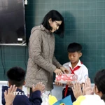 Cô giáo chủ nhiệm trao quà cho em Nguyễn Anh Tín, học sinh lớp 5D Trường tiểu học Lâm Hưng, bị thiệt hại nặng do mưa lũ. (Ảnh: Hồng Hiếu/TTXVN)