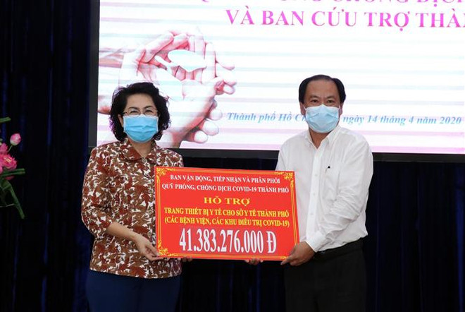 Bà Tô Thị Bích Châu, Chủ tịch Ủy ban MTTQ Việt Nam Thành phố trao tượng cho ông Nguyễn Hoài Nam, Phó Giám đốc Sở Y tế Thành phố số tiền ủng hộ để mua sắm trang thiết bị y tế (đợt 1) và hỗ trợ bác sỹ, y tá, nhân viên y tế tham gia công tác phòng, chống dịch COVID-19. (Ảnh: Xuân Khu/TTXVN). Tiếp thêm sức mạnh cho công tác phòng, chống dịch COVID-19 ảnh 1