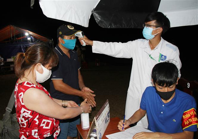 Người dân được sát khuẩn tay và kiểm tra thân nhiệt tại chốt kiểm dịch trên đường Hồ Chí Minh, xã Hòa Phú, thành phố Buôn Ma Thuột, tỉnh Đắk Lắk. (Ảnh: Tuấn Anh/TTXVN) Những 'lá chắn thép' trong phòng, chống đại dịch COVID-19 ảnh 2