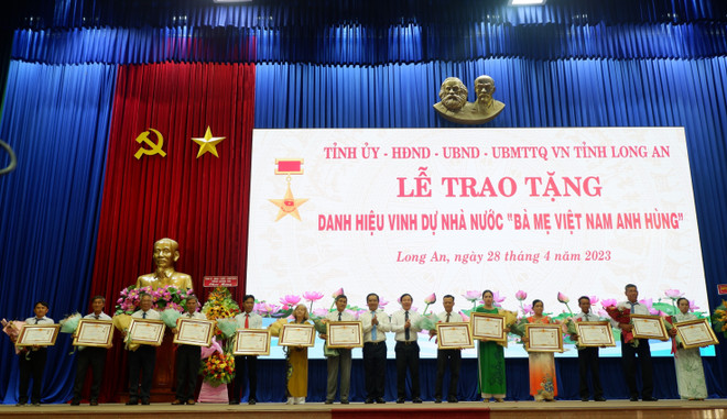 Lãnh đạo tỉnh Long An trao tặng danh hiệu vinh dự Nhà nước Bà mẹ Việt Nam Anh hùng cho thân nhân 13 Mẹ. (Ảnh: Đức Hạnh /TTXVN) Long An: Truy tặng danh hiệu cho 13 Mẹ Việt Nam anh hùng ảnh 1