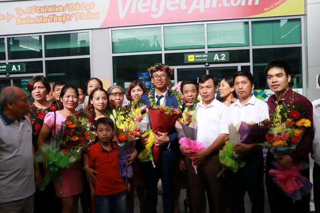 Lãnh đạo tỉnh, Sở Giáo dục và Đào tạo tỉnh Nghệ An, gia đình và các thầy cô giáo đón em Vũ Đức Vinh tại sân bay Vinh. (Ảnh: Bích Huệ/TTXVN) Nghệ An đón học sinh đoạt Huy chương bạc Olympic Toán quốc tế ảnh 1