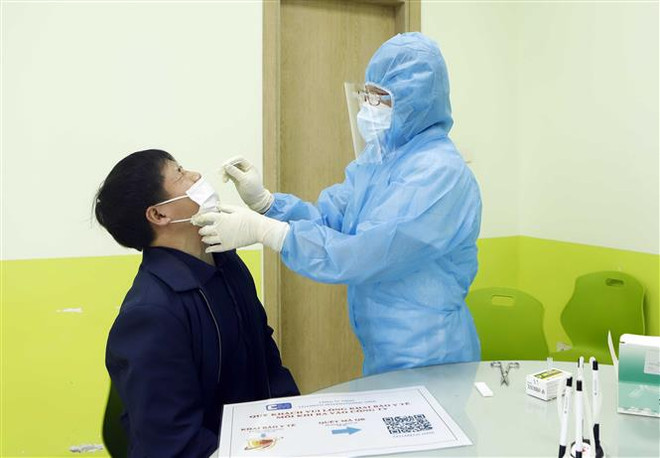 Lấy mẫu xét nghiệm COVID-19. (Nguồn: TTXVN) Những tỉnh nào yêu cầu người dân xét nghiệm, cách ly khi về đón Tết? ảnh 1