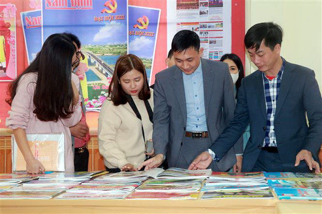 Đại biểu xem các ấn phẩm báo Trung ương và địa phương tại một Hội báo Xuân. (Ảnh: Văn Đạt/TTXVN) Ông Lê Quốc Minh: 'Báo chí chính thống không thể đứng yên' ảnh 3