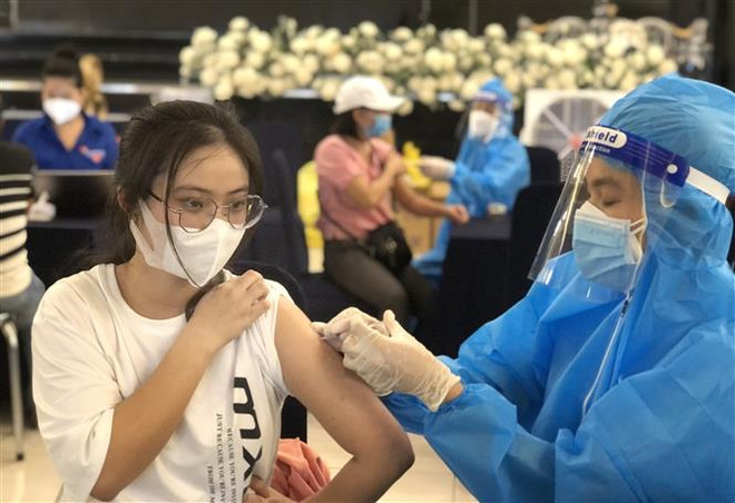 Cận cảnh lấy vaccine ngừa COVID-19. (Ảnh: Văn Dũng/TTXVN) Nghị quyết họp Chính phủ: Xây dựng lộ trình tiêm vaccine cho trẻ em ảnh 2