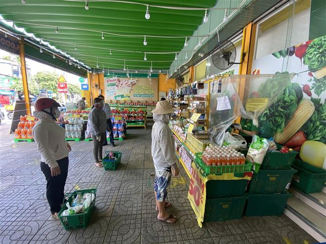 Người dân xếp hàng vào mua thực phẩm tại cửa hàng Bách hóa xanh ở Thành phố Hồ Chí Minh. (Ảnh: Thành Chung/TTXVN) Kiểm soát chặt thị trường hàng hóa TP.HCM và các tỉnh phía Nam ảnh 1