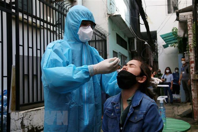 Hướng dẫn người dân tự test nhanh tại nhà. (Ảnh: Thanh Vũ/TTXVN) TP.HCM thí điểm cách ly tập trung 7 ngày đối với F0 không triệu chứng ảnh 1