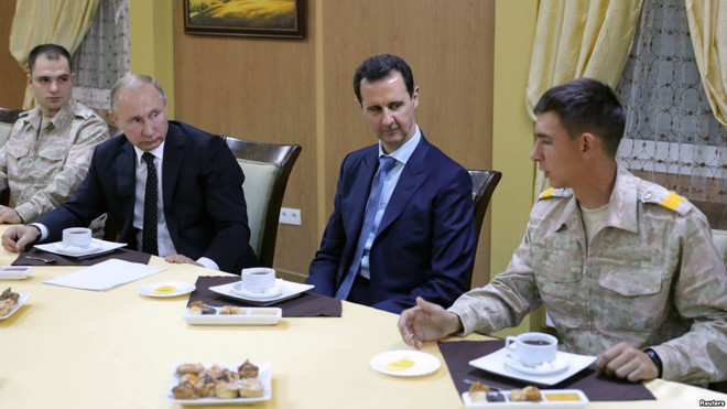 Tổng thống Nga Vladimir Putin và Tổng thống Syria Assad gặp gỡ binh sỹ tại căn cứ Hmeymim. (Nguồn: Reuters) Nga bắt đầu rút một phần binh lính và thiết bị quân sự khỏi Syria ảnh 1
