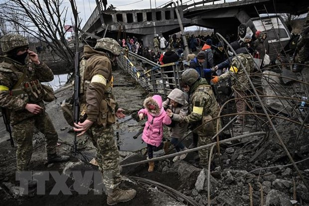 Người dân sơ tán khỏi thành phố Irpin, tây bắc thủ đô Kiev, Ukraine. (Ảnh: AFP/TTXVN) Khủng hoảng Ukraine được giải quyết khi Nga, phương Tây đạt thỏa thuận ảnh 1
