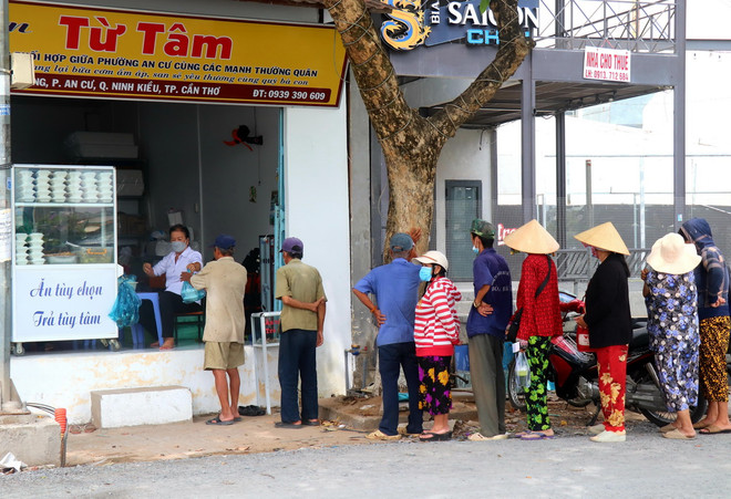 Người dân xếp hàng đợi nhận suất cơm trưa miễn phí tại quán cơm Từ Tâm. (Ảnh: Thu Hiền/TTXVN) ttxvn_Quan com tu tam 3.jpg