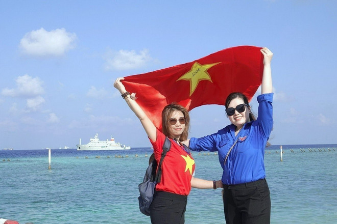 Kiều bào tự hào giương cao lá cờ Tổ quốc trên đảo Sinh Tồn Đông. (Ảnh: Thu Phương/TTXVN) ttxvn_kieu bao 2.jpg
