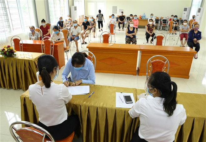 Phường Nguyễn Trãi (quận Hà Đông, Hà Nội) tổ chức chi trả tiền hỗ trợ theo NQ 68/NQ-CP cho 100 trường hợp được phê duyệt. (Ảnh: Hoàng Hiếu/TTXVN) Những vướng mắc trong việc hỗ trợ doanh nghiệp vượt 'bão COVID-19' ảnh 1