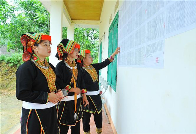 Đồng bào dân tộc Dao xem danh sách cử tri tham gia bầu cử đại biểu Quốc hội khóa XV và bầu cử đại biểu hội đồng nhân dân các cấp nhiệm kỳ 2021-2026 được niêm yết tại khu vực bỏ phiếu số 7 thuộc xã Phương Giao, huyện Võ Nhai, tỉnh Thái Nguyên. (Ảnh: Minh Đức/TTXVN) Niềm tự hào và trách nhiệm công dân khi cầm trên tay lá phiếu bầu cử ảnh 2