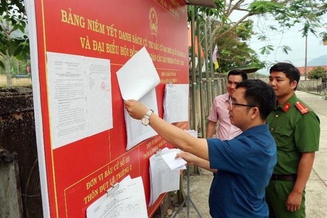 Bảng niêm yết danh sách cử tri tại trụ sở xã Trung Sơn, huyện A Lưới, tỉnh Thừa Thiên-Huế. (Ảnh: Đỗ Trưởng/TTXVN) Niềm tự hào và trách nhiệm công dân khi cầm trên tay lá phiếu bầu cử ảnh 1