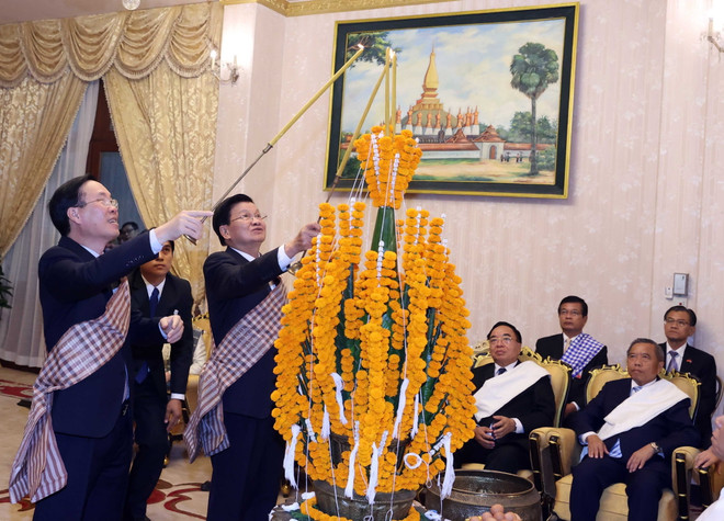 Chủ tịch nước Võ Văn Thưởng và Tổng Bí thư, Chủ tịch nước Lào Thongloun Sisoulith tại lễ buộc chỉ cổ tay cầu may nhân dịp Tết cổ truyền Bunpimay của Lào. (Ảnh: Thống Nhất/TTXVN) Tạo xung lực mới cho hợp tác Việt Nam-Lào trên tất cả các lĩnh vực ảnh 3