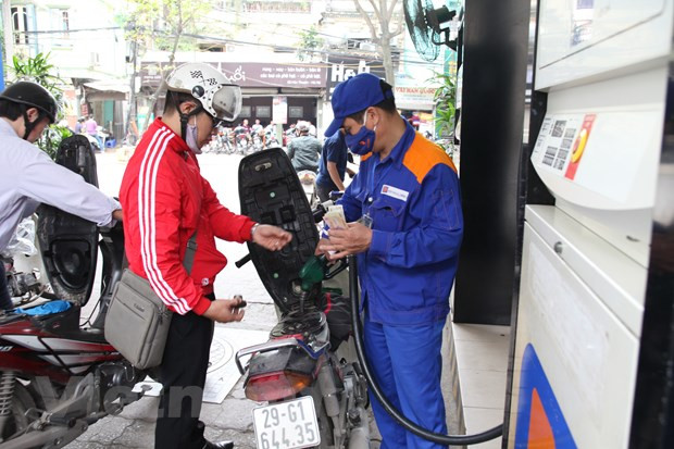 Nhân viên Petrolimex đang bán xăng cho khách hàng. (Ảnh: Đức Duy/Vietnam+) Điều hành giá xăng dầu: Cần nhạy bén, linh hoạt trong từng tình huống ảnh 2