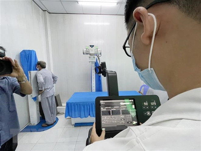 Bệnh nhân đầu tiên tại xã đảo Thạnh An, huyện Cần Giờ được chụp X-quang phổi bằng ứng dụng trí tuệ nhân tạo. (Ảnh: Đinh Hằng/TTXVN) TP.HCM: Bác sỹ trẻ vượt khó, mang bình an đến xã đảo Thạnh An ảnh 2