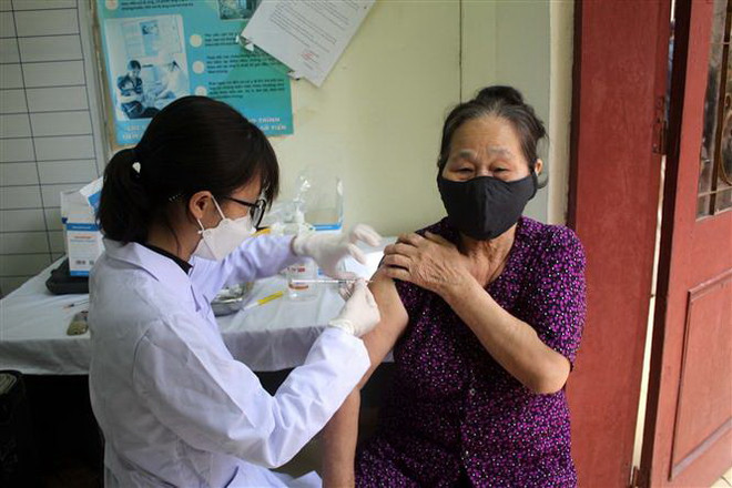 Nhân viên Trạm y tế phường Lam Sơn, thành phố Thanh Hóa tiêm vaccine phòng dịch COVD-19 cho người dân. (Ảnh: Nguyễn Nam/TTXVN) Trung bình số tử vong do COVID-19 tuần qua là 81 ca mỗi ngày ảnh 1