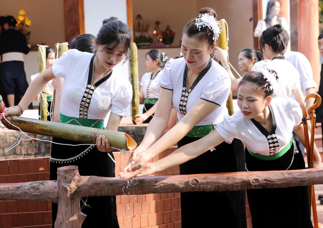 Người dân cùng du khách thập phương rửa tay để cầu may bằng nước được lấy lên từ mó nước, nơi Nàng Han sau khi thắng trận trở về cởi xiêm y tắm gội cùng ngựa bay về trời. (Ảnh: Quý Trung/TTXVN) ttxvn_le hoi nang han (8).jpg