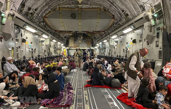 Người dân Afghanistan bên trong máy bay quân sự Mỹ, chuẩn bị được sơ tán khỏi sân bay quốc tế ở Kabul. (Ảnh: AFP/TTXVN) Taliban yêu cầu Mỹ ngừng sơ tán những người Afghanistan có chuyên môn ảnh 1