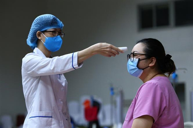 Kiểm tra thân nhiệt. (Ảnh minh họa. Nguồn: TTXVN) Tạm dừng xuất khẩu thuốc phòng, chống COVID-19 từ ngày 16/4 ảnh 1