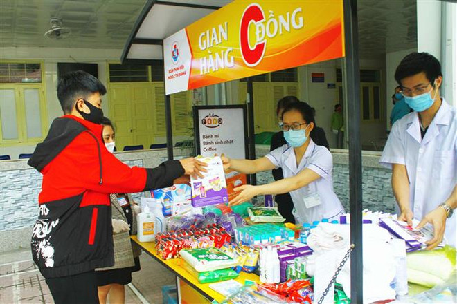 Bệnh nhân và người nhà bệnh nhân đến gian hàng 0 đồng tại Bệnh viện Sản nhi Nghệ An. (Ảnh: Tá Chuyên/TTXVN) Gian hàng '0 đồng' giúp đỡ bệnh nhi trong mùa dịch COVID-19 ảnh 1