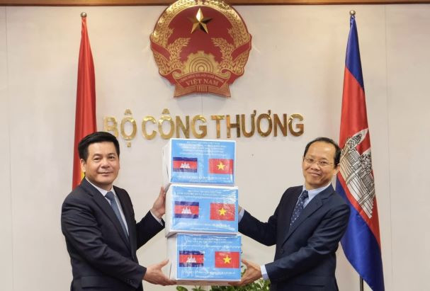 Bộ trưởng Công Thương Nguyễn Hồng Diên trao tượng trưng 20.000 khẩu trang phòng, chống dịch COVID-19 cho Đại sứ Campuchia. (Ảnh: Trần Việt/TTXVN) Việt Nam-Campuchia thúc đẩy quan hệ thương mại, công nghiệp ảnh 1