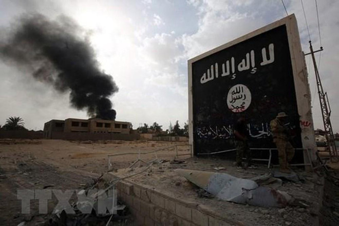 Cờ của tổ chức Nhà nước Hồi giáo (IS) tự xưng tại al-Qaim tỉnh Anbar, Syria, gần biên giới Syria ngày 3/11/2017. (Nguồn: AFP/TTXVN) Ngoại trưởng Mỹ: IS đang củng cố sức mạnh ở một số khu vực ảnh 1