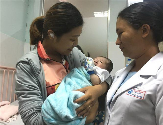 Niềm vui của gia đình bệnh nhân sau khi bé được phẫu thuật và hồi phục. (Ảnh: Đinh Hằng/TTXVN) TP Hồ Chí Minh: Một bệnh nhi được phẫu thuật tim khi mới 3 ngày tuổi ảnh 1