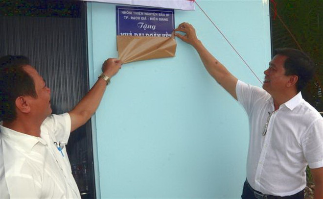 Nghi thức trao nhà đại đoàn kết cho một hộ nghèo ở Kiên Giang. (Ảnh: Lê Sen/TTXVN) Phát triển kinh tế và bảo đảm an sinh xã hội: Hướng tới sự hài hòa ảnh 1