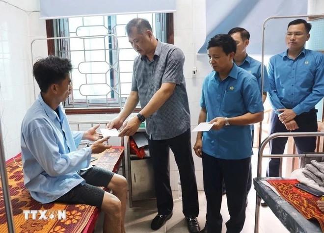 Chủ nhiệm Ủy ban Kiểm tra Tổng Liên đoàn Lao động Việt Nam Nguyễn Minh Dũng trao hỗ trợ các công nhân bị tai nạn do sạt lở đất, khi thi công Dự án đường điện 500KV mạch 3, đoạn đi qua thị xã Kỳ Anh, Hà Tĩnh. (Ảnh: TTXVN) z5550381714328_532a2a73e70ab1441a77f3de4e9f570b.jpg
