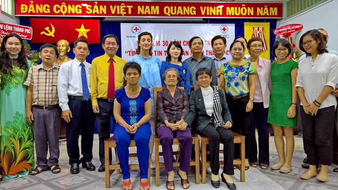 Ban thường trực Hội Chữ thập Đỏ Thành phố Hồ Chí Minh, đại diện Ủy ban Chữ thập đỏ Quốc tế (ICRC) tại Việt Nam cùng đại diện các gia đình có người thân mất liên lạc đã được đoàn tụ chụp ảnh lưu niệm tại lễ kỷ niệm. (Ảnh: Thế Anh/TTXVN) Hỗ trợ 348 gia đình ở TP.HCM tìm được thân nhân mất liên lạc ảnh 1