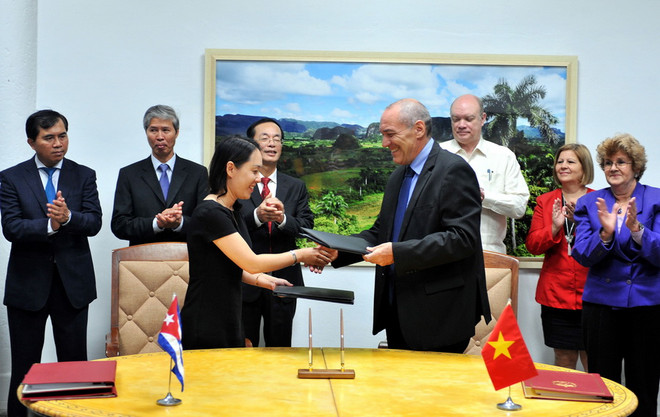 Đại diện công ty Davac của Việt Nam và Viện Vắcxin Finlay của Cuba trao đổi văn bản thỏa thuận về cùng phát triển vắcxin chống thương hàn. (Ảnh: Vũ Lê Hà/TTXVN) Kết thúc kỳ họp thứ 34 Ủy ban liên chính phủ Việt Nam-Cuba ảnh 1