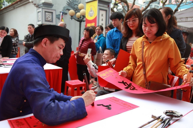 Người dân xin chữ tại buổi lễ. (Ảnh: TTXVN phát) ttxvn_khai but 2.jpg