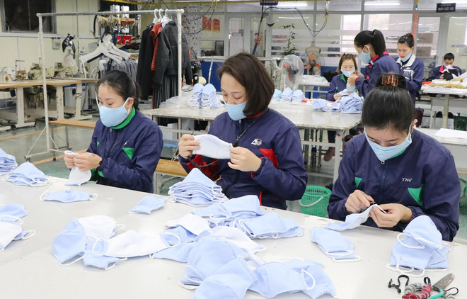 Công nhân Công ty cổ phần đầu tư và thương mại TNG kiểm tra sản phẩm trước khi xuất xưởng. (Ảnh: Hoàng Nguyên/ TTXVN) Bảo đảm chất lượng khẩu trang, kit xét nghiệm phòng, chống COVID-19 ảnh 1