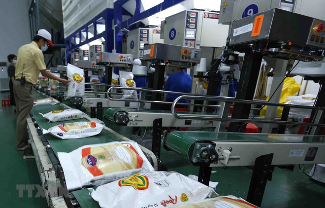 Đóng gói sản phẩm gạo xuất khẩu tại nhà máy của Công ty Cổ phần Nông nghiệp công nghệ cao Trung An, quận Thốt Nốt, thành phố Cần Thơ. (Ảnh: Vũ Sinh/TTXVN) Đề xuất giải pháp tháo gỡ vướng mắc về hạn ngạch xuất khẩu gạo ảnh 1
